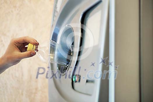 Hand putting a plastic bottle in the machine Hand putting a plastic bottle in the machine