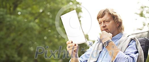 Middle aged man reading from ipad Middle aged man reading from ipad