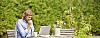 Man sitting in the garden with laptop