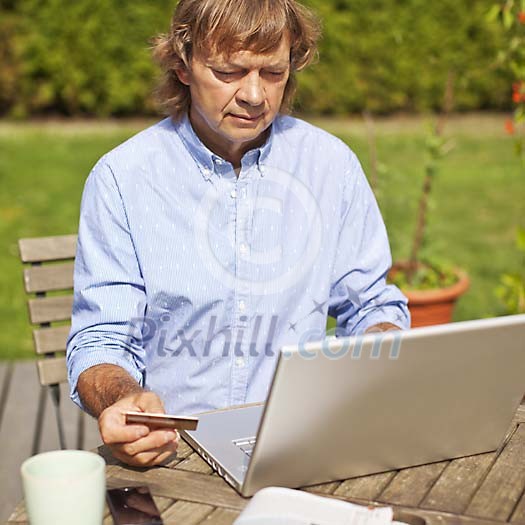 Man sitting in the garden with laptop Man sitting in the garden with laptop