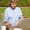 Man sitting in the garden with laptop