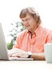 Man typing on laptop outside