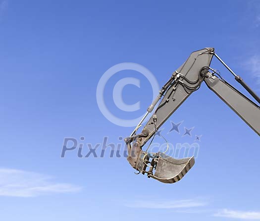 Excavator bucket on a blue sky background Excavator bucket on a blue sky background
