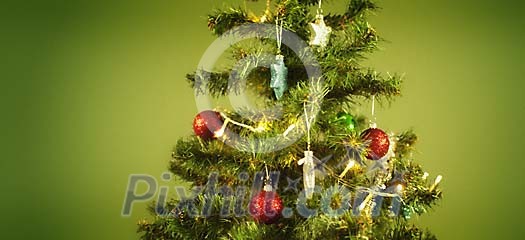 Decorated christmas tree on a green background