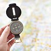 Hand holding a compass on a map background
