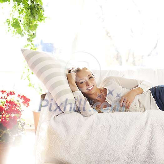 Smiling woman lying on the sofa Smiling woman lying on the sofa