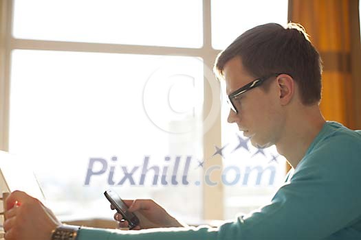 Man in the office looking at his phone Man in the office looking at his phone