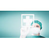 Female surgeon touching a white cross on a virtual screen