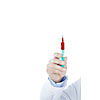 Hand holding a syringe filled with red fluid