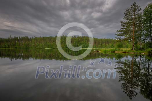 Dark clouds above the lake and forest Dark clouds above the lake and forest