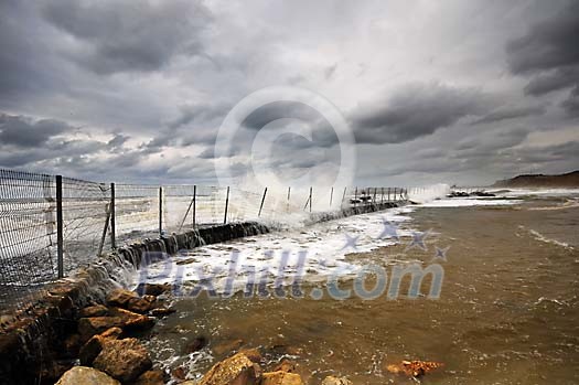 Stormy waves splashing over metallic fence Stormy waves splashing over metallic fence