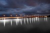 Lighted bridge on the river in the evening