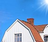 White house with red tiles and a blue sky with sunshine