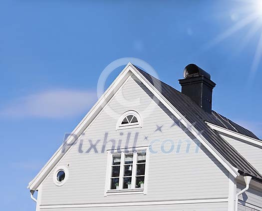 grey wooden house with black tin roof and a blue sky with sunshine grey wooden house with black tin roof and a blue sky with sunshine