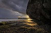 Big rock by the shore at the sunset