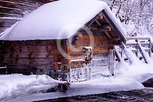 Ice on the house wall next to a river Ice on the house wall next to a river
