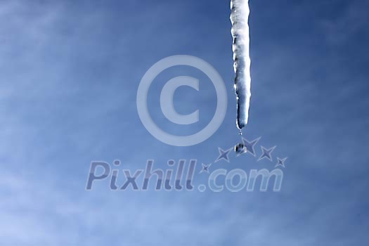 Icicle melting on a blue background Icicle melting on a blue background