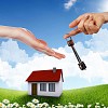 Human hand against blue sky background and house