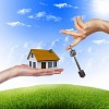 Human hand against blue sky background and house
