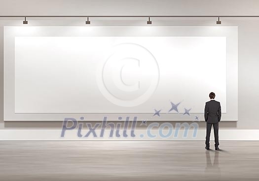 Business person standing near a blank billboard Business person standing near a blank billboard