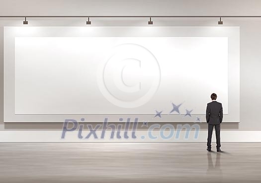 Business person standing near a blank billboard