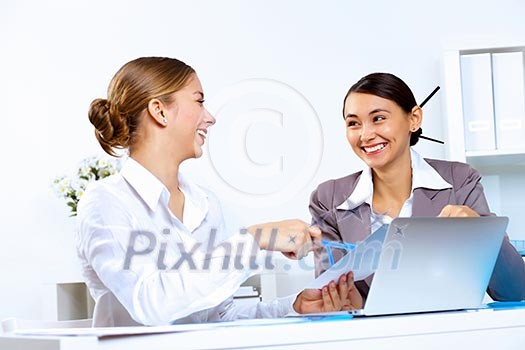 Young women in business wear working in office together Young women in business wear working in office together