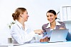 Young women in business wear working in office together