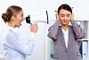 Young woman in business wear with megaphone in office