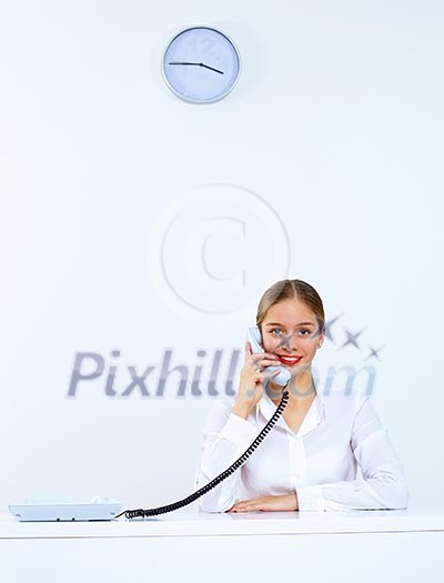 Young woman in business wear sitting with a phone in office Young woman in business wear sitting with a phone in office