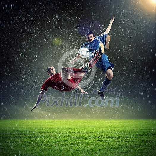 two football players in jump to strike the ball at the stadium two football players in jump to strike the ball at the stadium