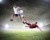 Two football players in jump to strike the ball at the stadium