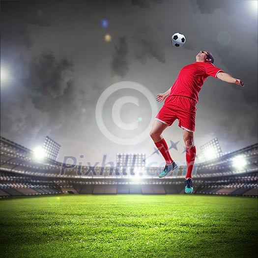 Football player in red shirt striking the ball at the stadium Football player in red shirt striking the ball at the stadium