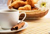 Breakfast coffee and croissants on a table on a light background.