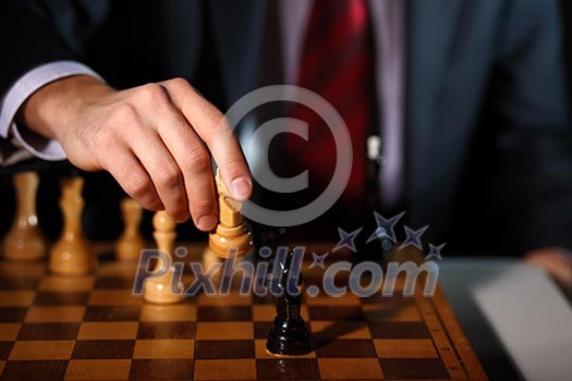 Image of a businessman in dark suit playing chess Image of a businessman in dark suit playing chess