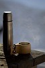 Coffee cup with a thermos on the terrace table
