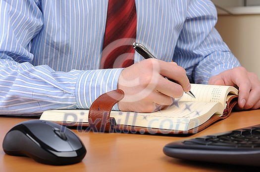 A young business man working in an office at his workplace. A young business man working in an office at his workplace.