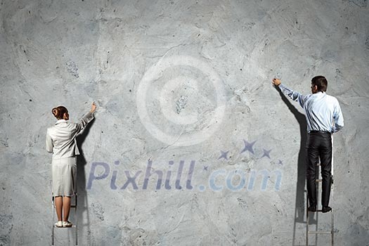 businesspeople standing on ladder drawing diagrams and graphs on wall businesspeople standing on ladder drawing diagrams and graphs on wall