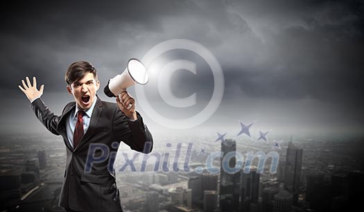 Young businessman in black suit screaming into megaphone Young businessman in black suit screaming into megaphone