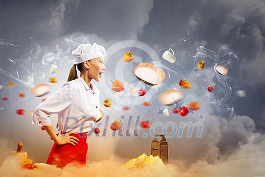 Asian female cook in anger with flyung vegetables against color background with shine effects