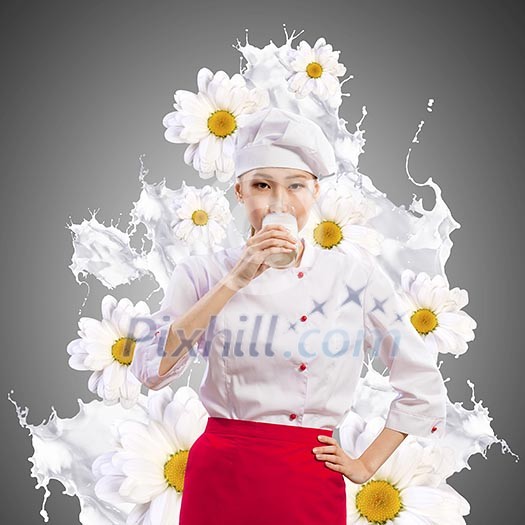 Asian female cook against milk splashes in red apron against flower background drinking milk Asian female cook against milk splashes in red apron against flower background drinking milk