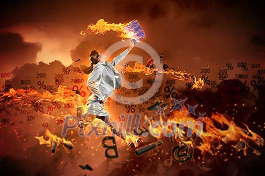 Image of a businesswoman with a fire jumping high against flaming background Image of a businesswoman with a fire jumping high against flaming background