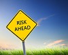 yellow road sign as a warning of risk ahead