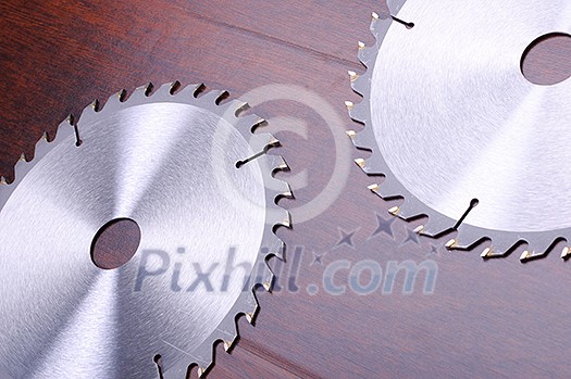 The metal disc is a circular saw on a dark background The metal disc is a circular saw on a dark background
