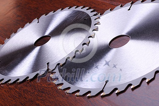 The metal disc is a circular saw on a dark background The metal disc is a circular saw on a dark background