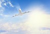 Image of flying airplane in sky with clouds at background