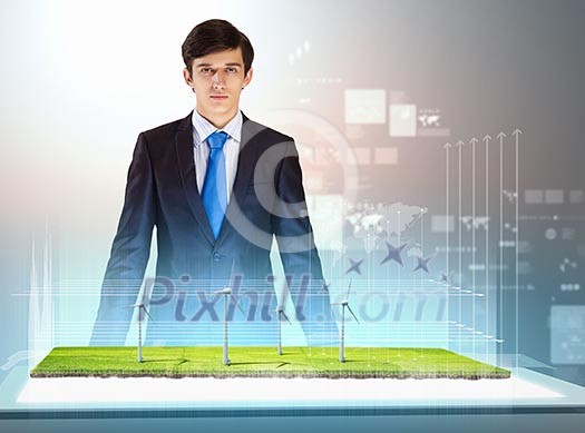 Image of young businessman looking at high-tech picture of windmills Image of young businessman looking at high-tech picture of windmills