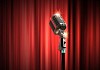 Single retro microphone against red curtains closed on the background