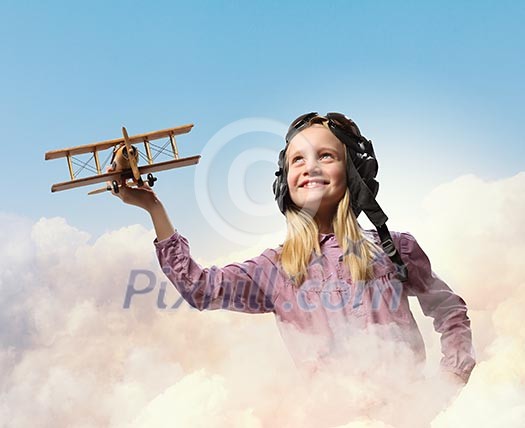 Image of little girl in pilots helmet playing with toy airplane against clouds background Image of little girl in pilots helmet playing with toy airplane against clouds background