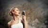 Image of female blonde singer holding microphone against smoke background