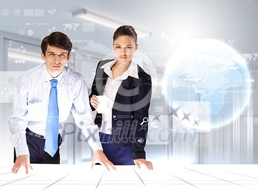 young businesspeople looking at high-tech image of globe young businesspeople looking at high-tech image of globe